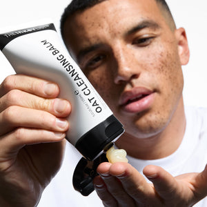 model squeezing Oat Cleansing Balm onto his hand