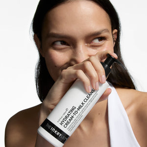 Woman holding a skincare product with a white background
