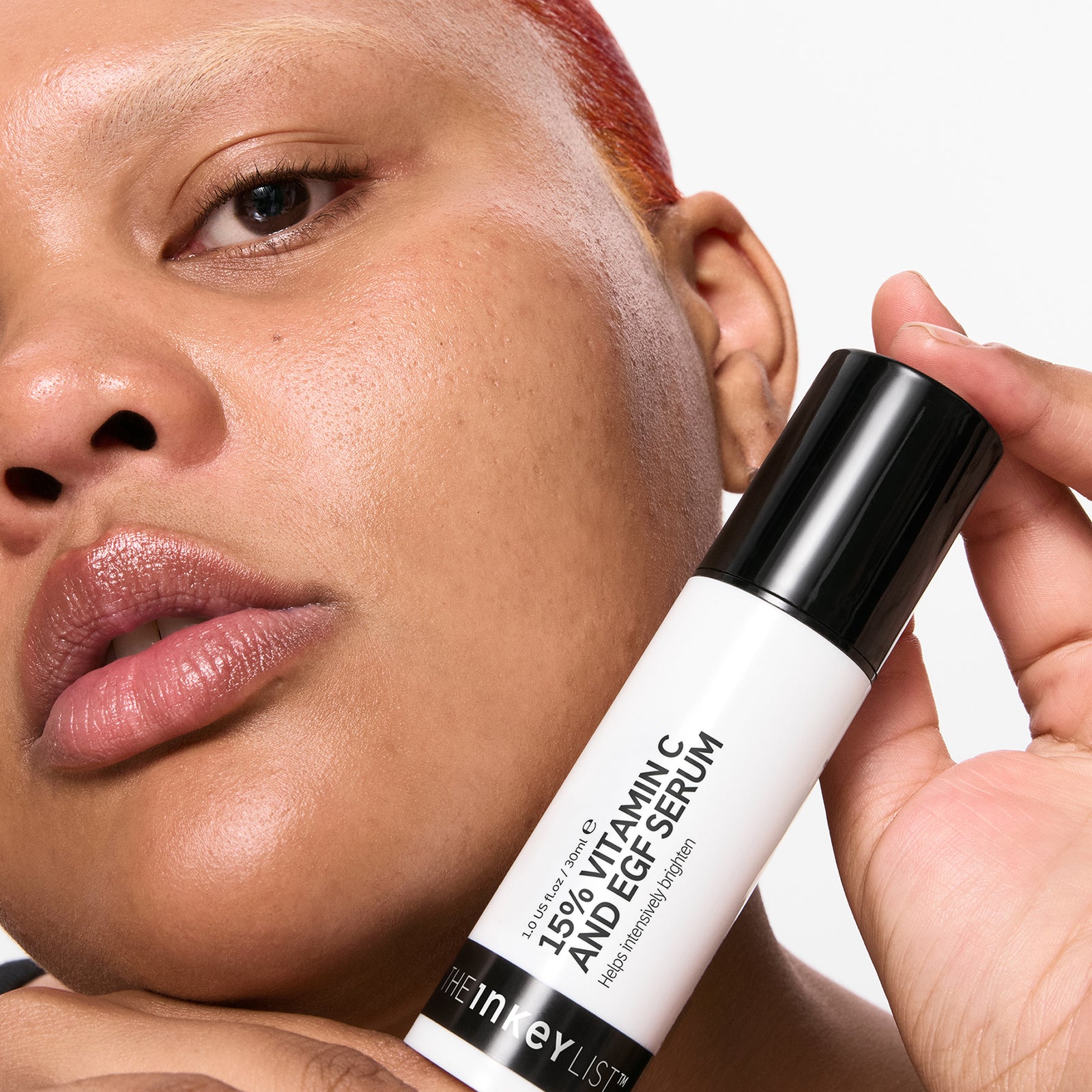 Person holding a 15% Vitamin C + EGF Serum with a neutral background