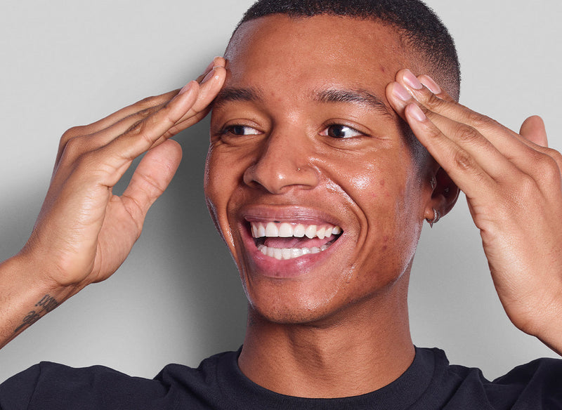 Model rubbing serum into his face