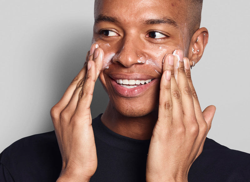 Male model applying skincare to his face