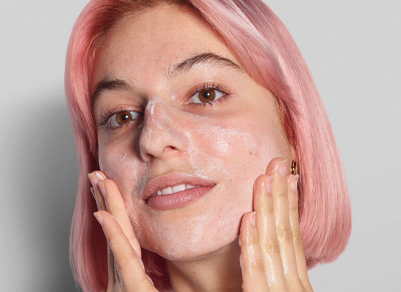 Model with pink hair applying product