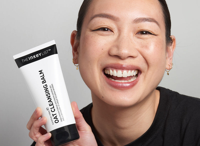 Model holding The INKEY List Oat Cleansing Balm product