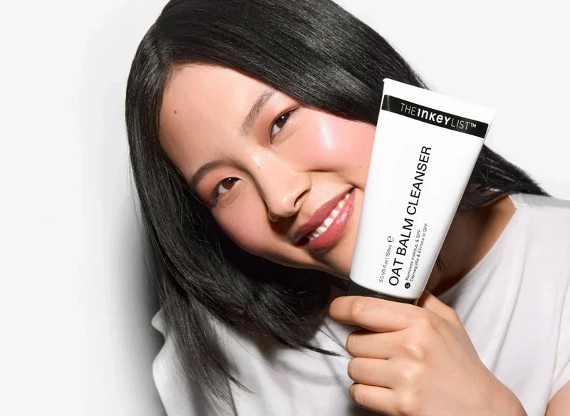 A woman holding the Oat Balm Cleanser