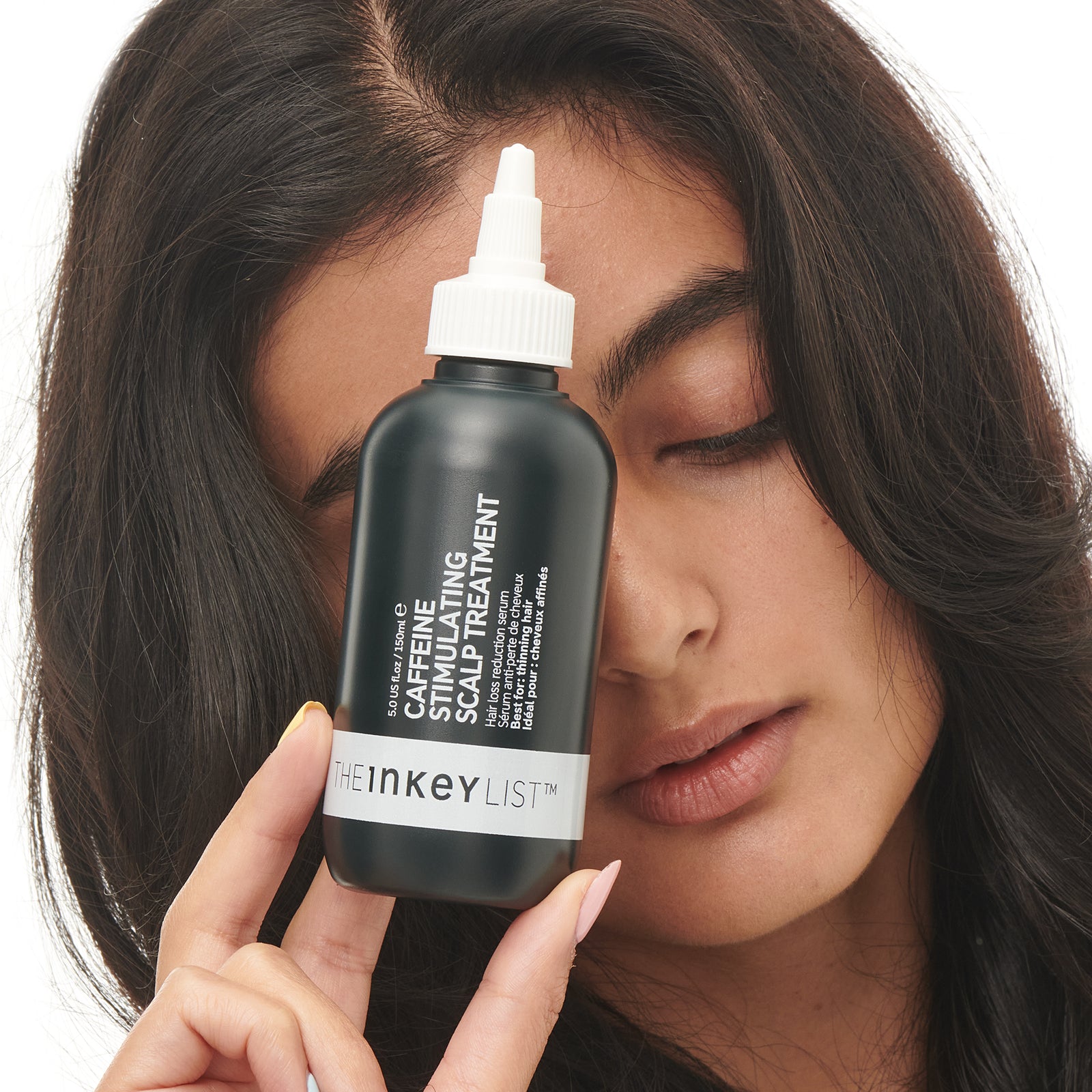 Model holding Caffeine stimulating scalp treatment