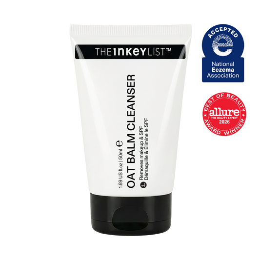 A white and black squeeze tube of THE INKEYLIST Oat Balm Cleanser, shown against a plain white background with two award badges on the right: a blue National Eczema Association Acceptance badge and an Allure Best of Beauty 2026 award badge.