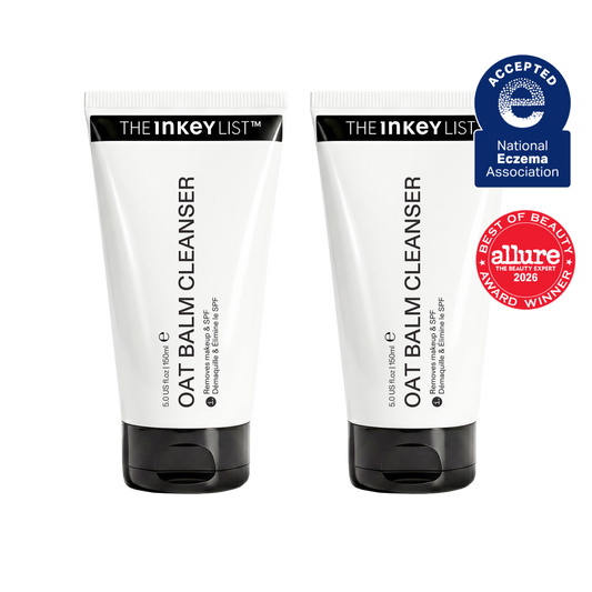 Two white tubes of OAT BALM CLEANSER by THE INKEY LIST with black caps, shown side by side on a white background with a blue and red award badge on the right.