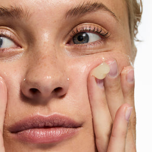 Model applying Oat Cleansing Balm to her face