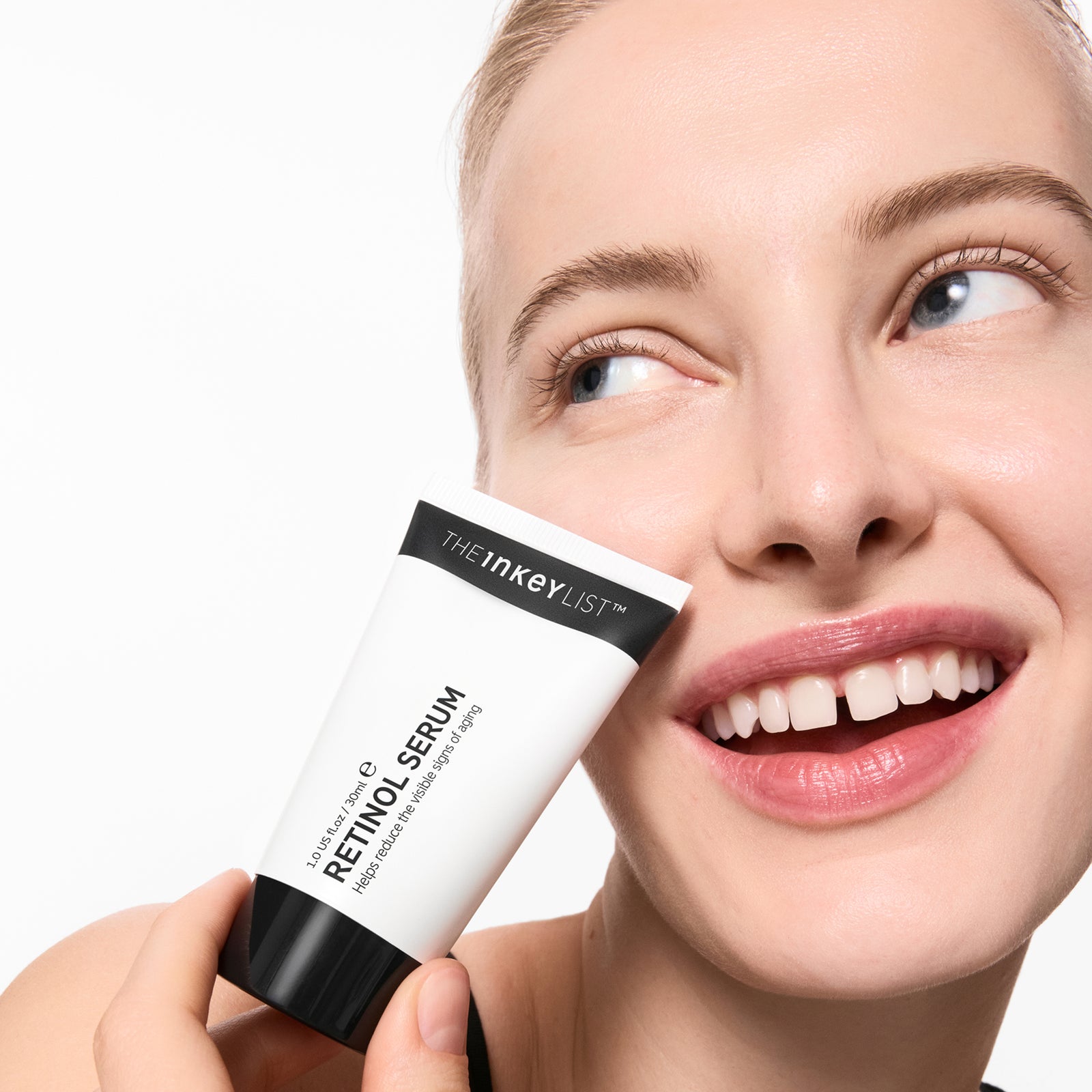 Woman holding Retinol Serumwith a plain background