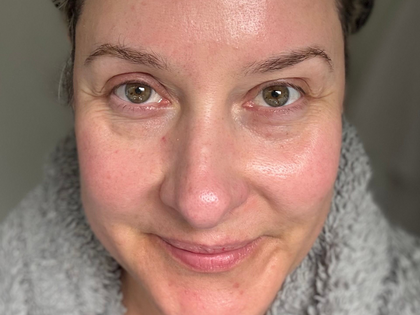 Close-up of a person wearing a gray sweater with a neutral background