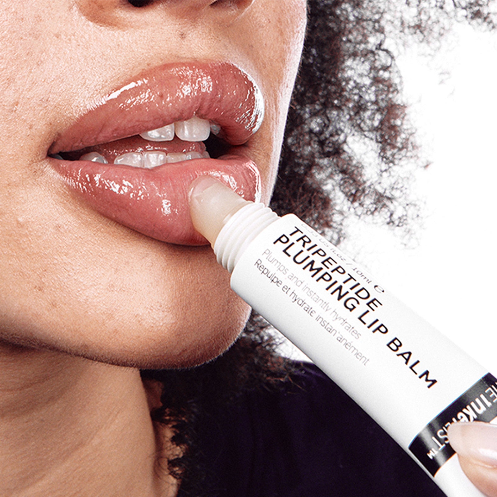 Close-up of a woman applying peptide-based lip treatment for enhanced lip volume.