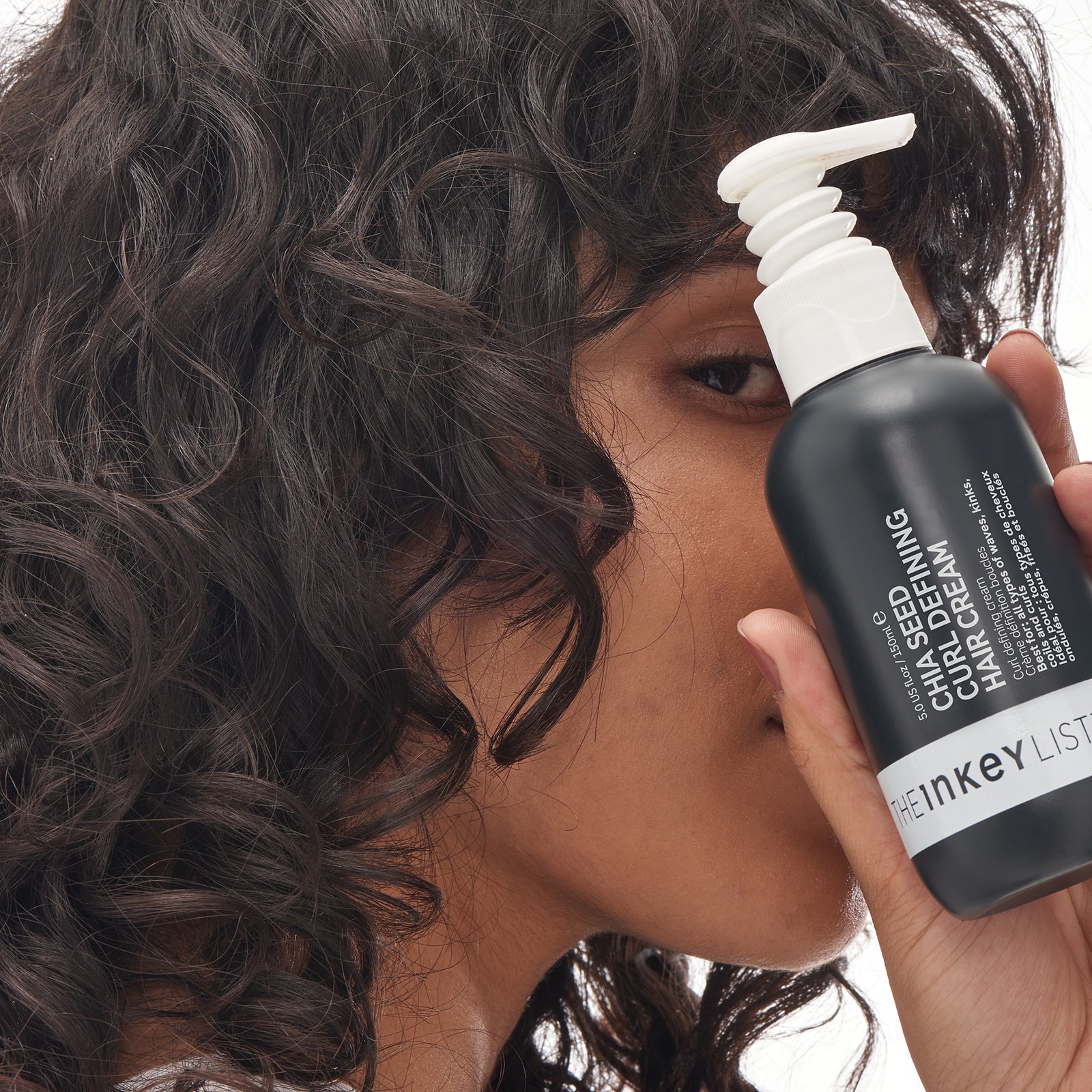 Chia seed curl defining hair treatment model holding bottle shot 